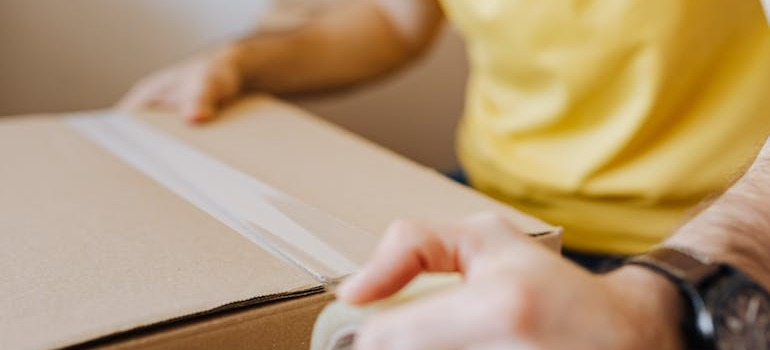 A person closing a box