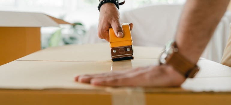 a mover packing a box as a part of moving services Philadelphia