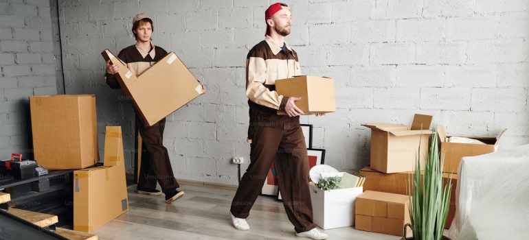 Two men carrying boxes