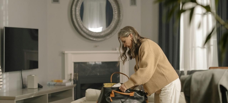 A senior woman is packing her bag.