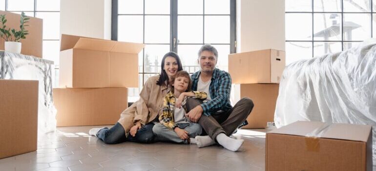 A Newly Moved Family Sitting on the Floor and waiting for International movers Philadelphia