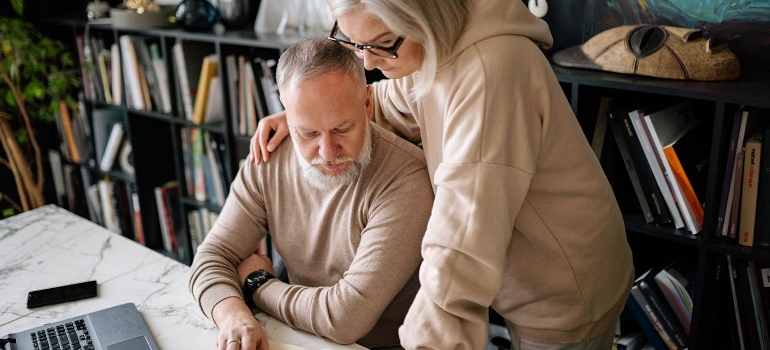 A senior couple is reading the notes on ways to make relocating as a senior less stressful.