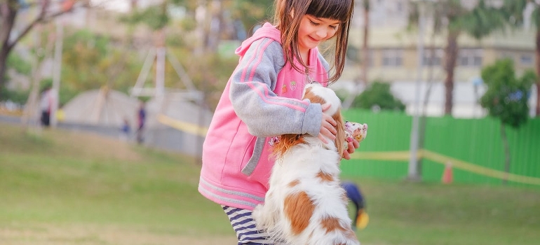 a girl playing with a dog after moving to Willow Grove with pets